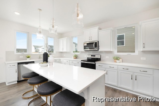 1219 Homecoming Blvd Unit Cc1-27, Ravenel, SC 29470 - kitchen featuring stainless steel appliances, a kitchen bar, backsplash, and white cabinetry