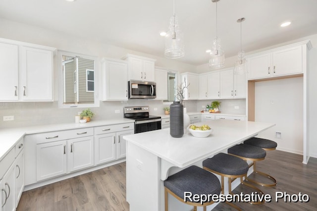 1219 Homecoming Blvd Unit Cc1-27, Ravenel, SC 29470 - kitchen with stainless steel appliances, white cabinetry, wood finished floors, and recessed lighting