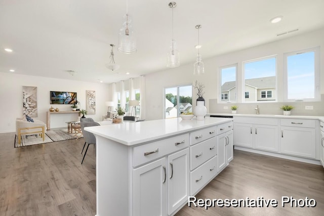 1219 Homecoming Blvd Unit Cc1-27, Ravenel, SC 29470 - kitchen with light wood-type flooring, recessed lighting, white cabinetry, light countertops, and a kitchen island