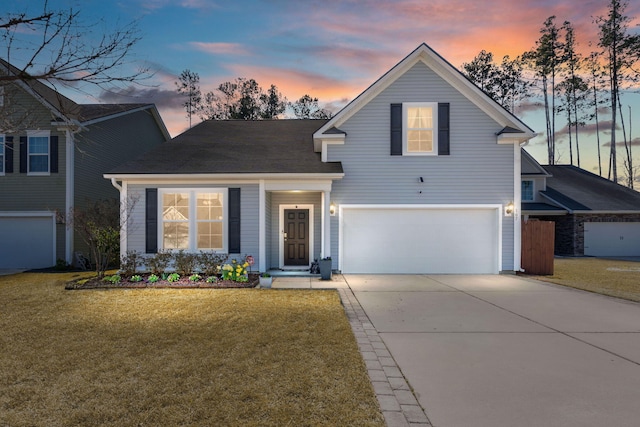 traditional home with a garage, concrete driveway, and a front lawn