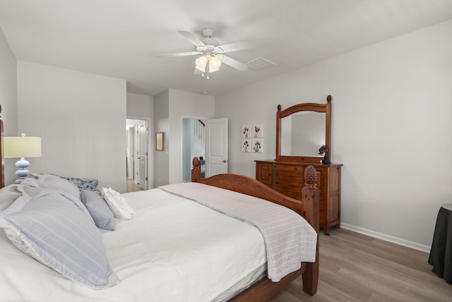 bedroom featuring a ceiling fan, baseboards, and wood finished floors