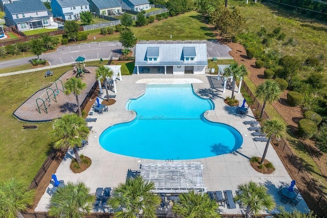 community pool with a patio area and fence