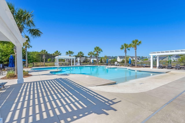 pool with a patio area, fence, and a pergola