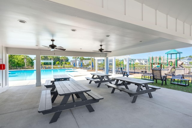 exterior space with a ceiling fan, a community pool, fence, and playground community