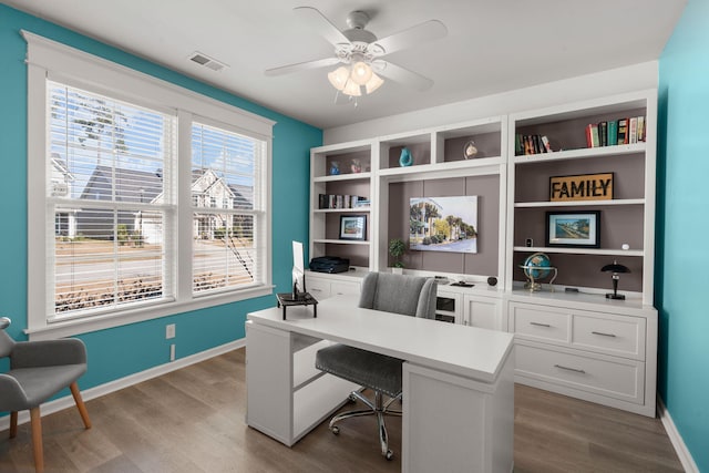 office featuring visible vents, ceiling fan, baseboards, and wood finished floors