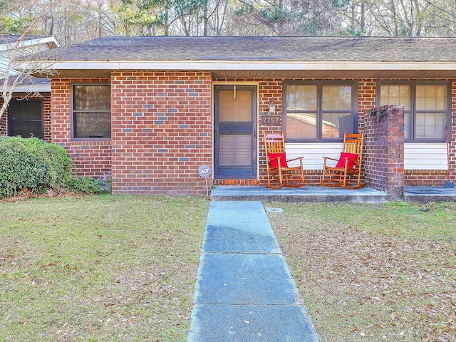 entrance to property with a lawn