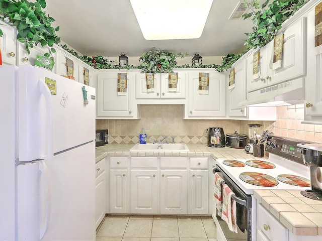 kitchen with tile counters, white appliances, premium range hood, sink, and tasteful backsplash