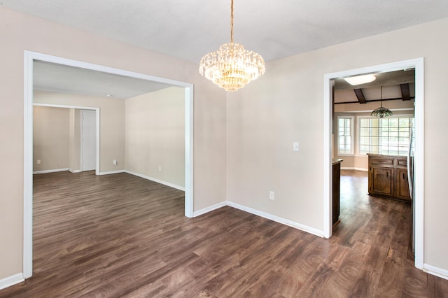 spare room featuring baseboards, a chandelier, dark wood-style flooring, and beamed ceiling