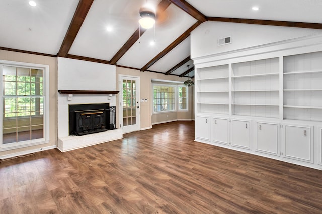 unfurnished living room with visible vents, lofted ceiling with beams, dark wood-type flooring, a ceiling fan, and a brick fireplace