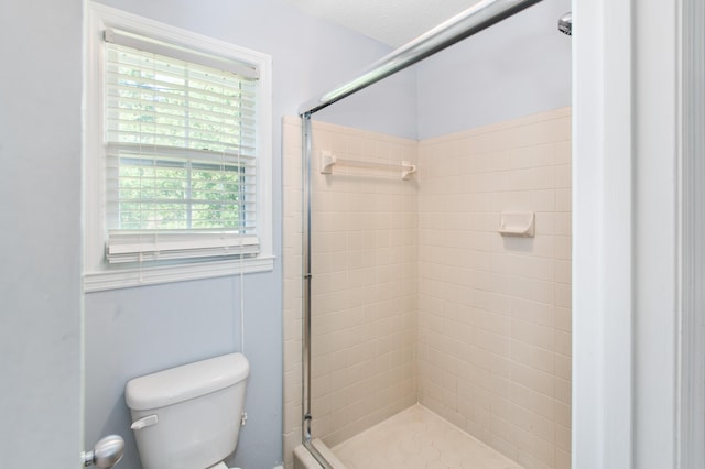 bathroom with a shower stall and toilet