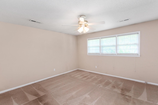 empty room featuring carpet floors, visible vents, and a textured ceiling