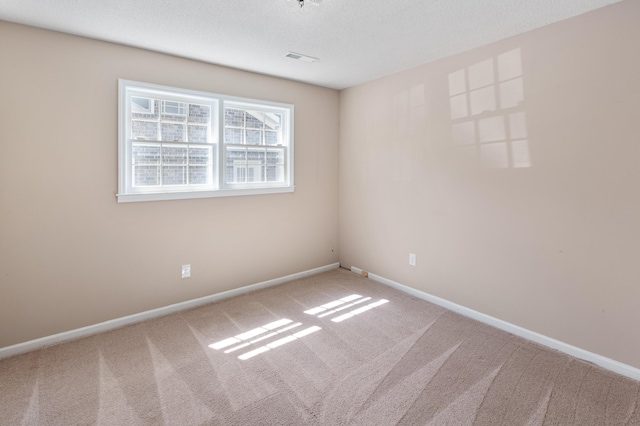 carpeted empty room with a textured ceiling, visible vents, and baseboards