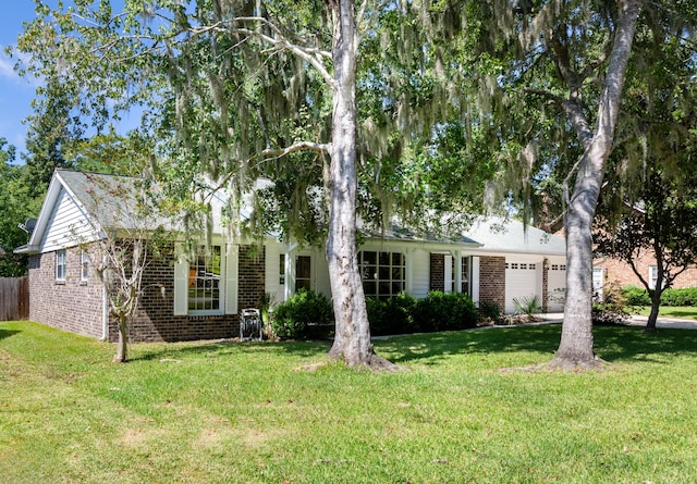 ranch-style house featuring an attached garage, a front lawn, and brick siding