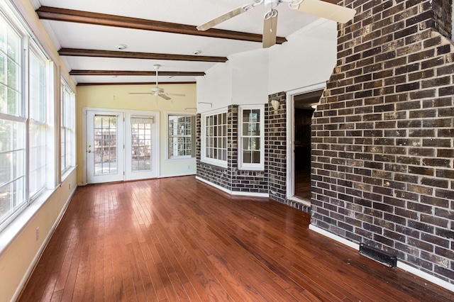 unfurnished sunroom featuring lofted ceiling with beams, ceiling fan, and a wealth of natural light