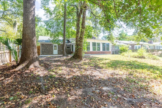 rear view of property with brick siding and fence