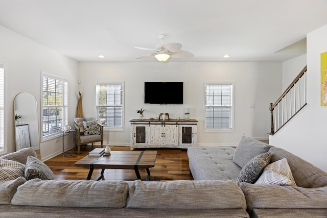 living room featuring baseboards, stairway, wood finished floors, and recessed lighting