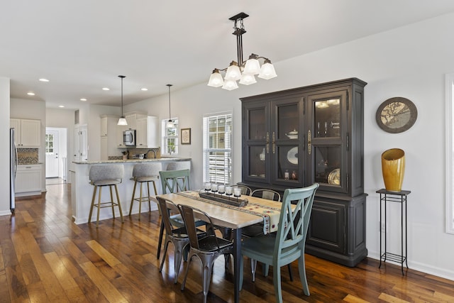 dining room with dark wood-style floors, baseboards, a chandelier, and recessed lighting