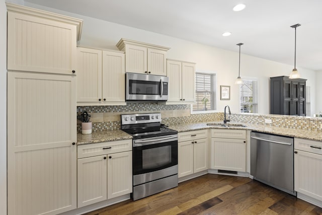 kitchen featuring stainless steel appliances, dark wood-style flooring, a sink, and tasteful backsplash