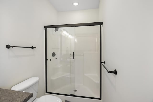 bathroom with toilet and a stall shower