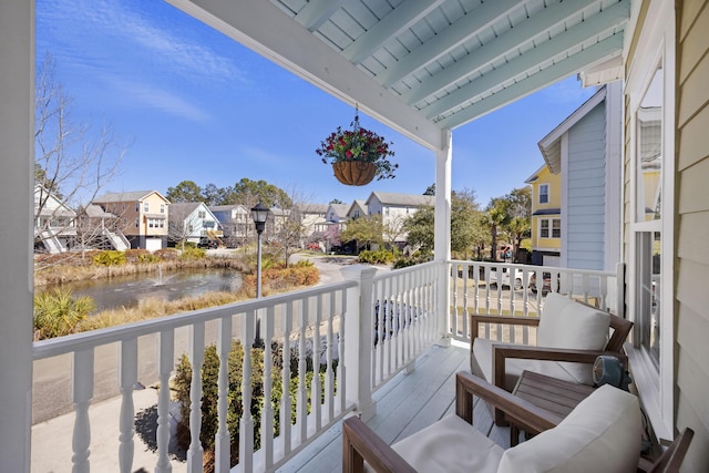 balcony with a residential view and a water view