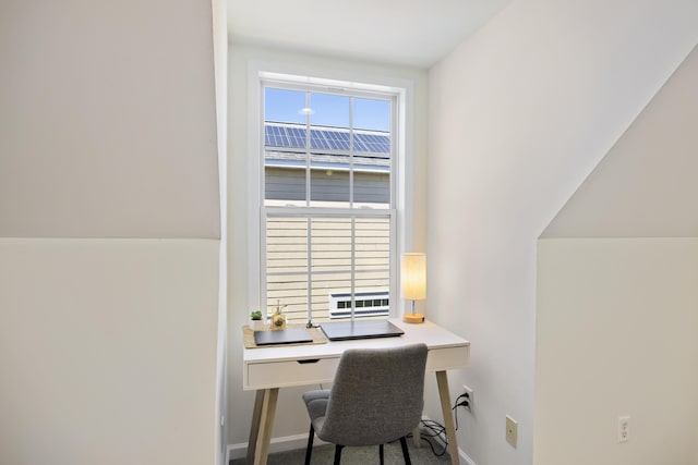 carpeted office space featuring baseboards