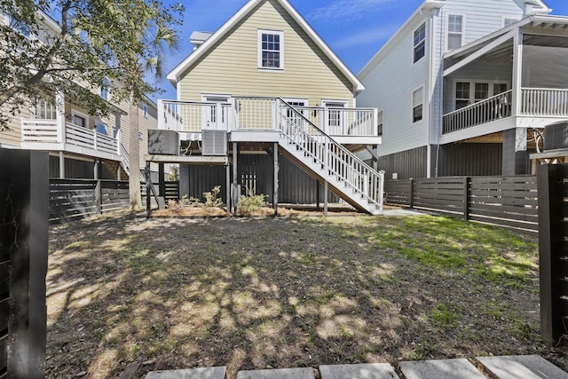 rear view of house with stairs, a deck, and a fenced backyard