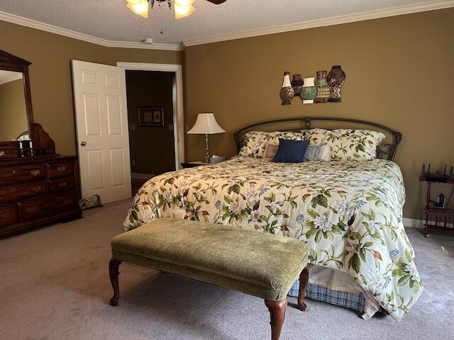 bedroom featuring ceiling fan, crown molding, and light colored carpet