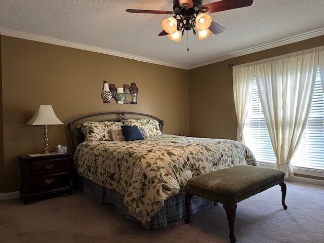 bedroom with ornamental molding, a textured ceiling, ceiling fan, and carpet floors