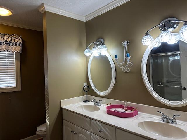 bathroom featuring ornamental molding, vanity, and toilet