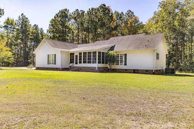 view of front of house with central AC unit, a front yard, and a sunroom