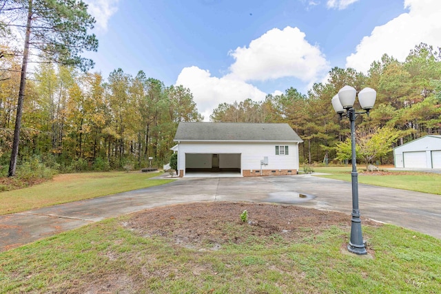 view of side of property featuring a garage, an outdoor structure, and a yard