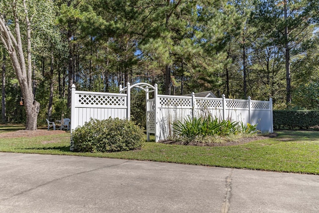 view of gate with a lawn