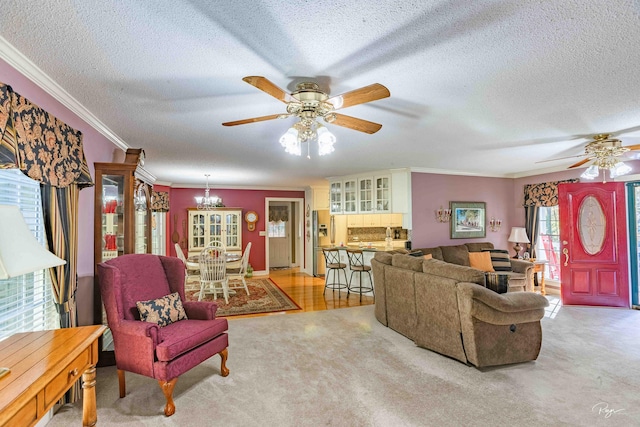 living room with ceiling fan with notable chandelier, a textured ceiling, light carpet, and crown molding