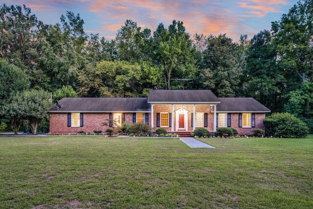 view of front of property with brick siding and a front lawn