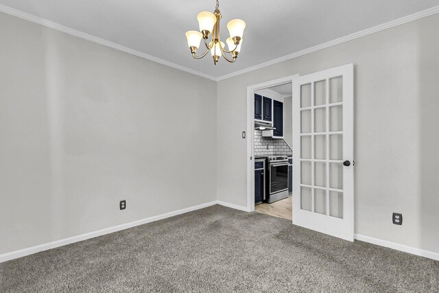 spare room with ornamental molding, a notable chandelier, baseboards, and light carpet