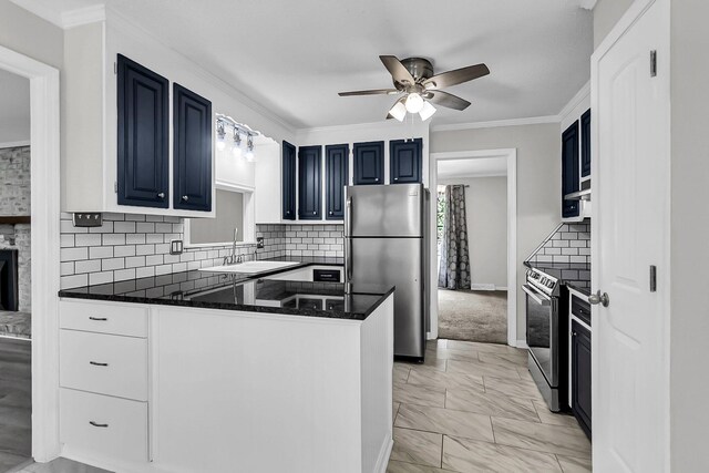 kitchen with crown molding, a peninsula, stainless steel appliances, blue cabinets, and a sink