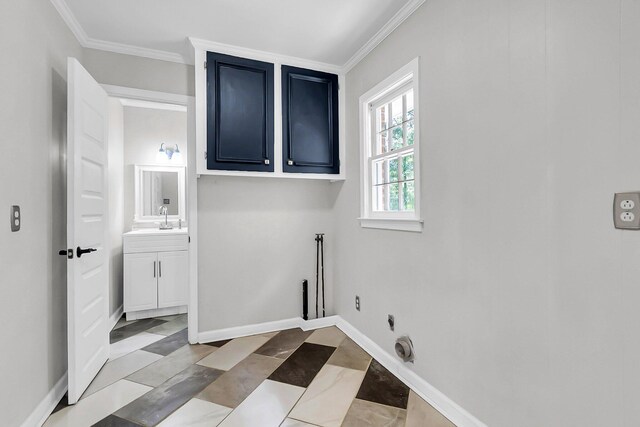 clothes washing area with crown molding, baseboards, cabinet space, electric dryer hookup, and a sink