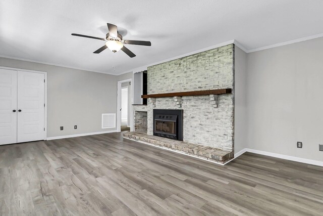 unfurnished living room featuring visible vents, baseboards, wood finished floors, and a fireplace