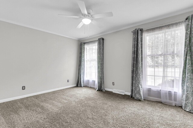 unfurnished room with crown molding, carpet, and visible vents