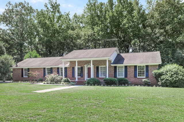 view of front of property with a shingled roof, a front lawn, brick siding, and crawl space