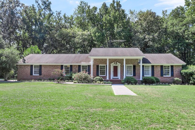 view of front of property with brick siding, covered porch, and a front yard