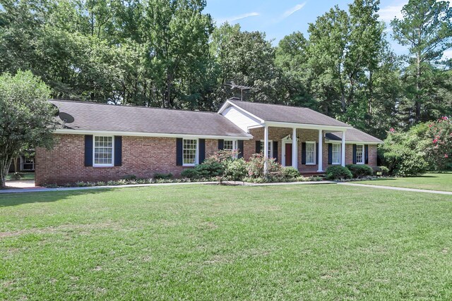 view of front of home featuring a front yard, a porch, and brick siding