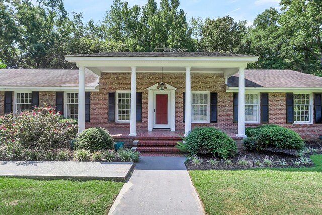 view of front facade with a front lawn and brick siding