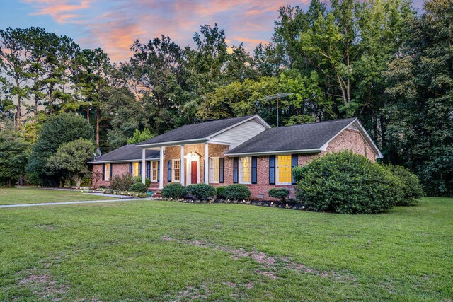 view of front of property with brick siding, a porch, and roof with shingles