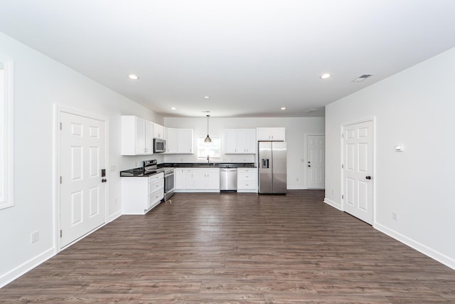 kitchen featuring stainless steel appliances, visible vents, white cabinetry, dark countertops, and pendant lighting