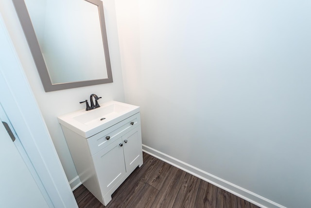 bathroom featuring baseboards, wood finished floors, and vanity