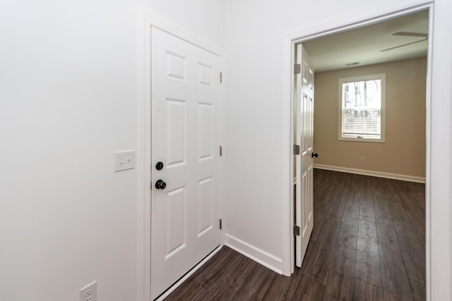 hall with dark wood-style floors and baseboards