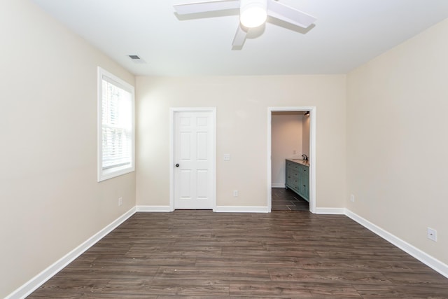 unfurnished bedroom featuring a ceiling fan, dark wood-style flooring, visible vents, and baseboards