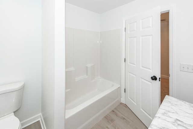 full bath with toilet, baseboards, wood finished floors, and shower / bathtub combination