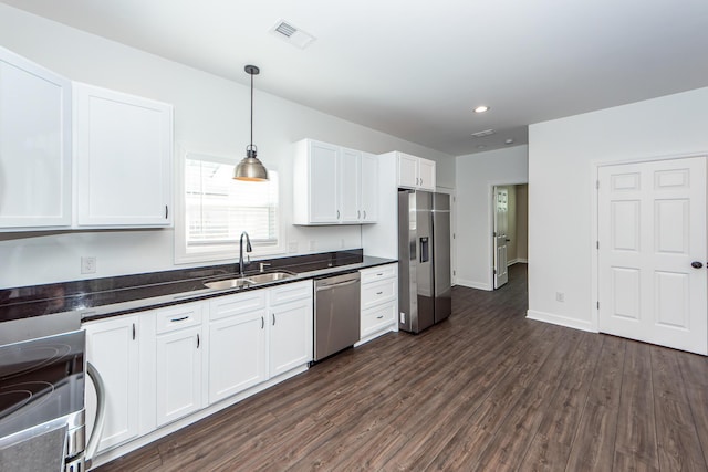 kitchen with visible vents, white cabinets, dark countertops, appliances with stainless steel finishes, and a sink